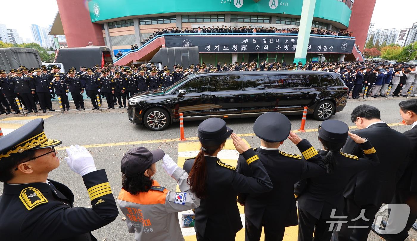 본문 이미지 - 부천 공장 화재 진압 과정에서 순직한 김진석 소방위의 영결식이 엄수된 19일 경기도 부천시 원미구 부천체육관에서 동료 소방관 등이 운구차량을 향해 마지막 인사를 하고 있다. (공동취재) 2026.10.19 ⓒ 뉴스1 구윤성 기자