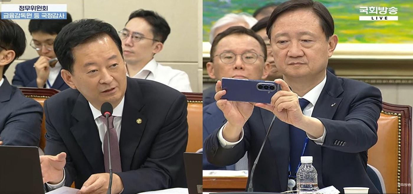 본문 이미지 - 이찬진 금융감독원장이 19일 서울 여의도 국회 정무위원회 국정감사에서 'OK홀딩스 대부의 최대 주주가 일본 회사가 될 가능성'을 지적하는 자료를 사진찍고 있다.