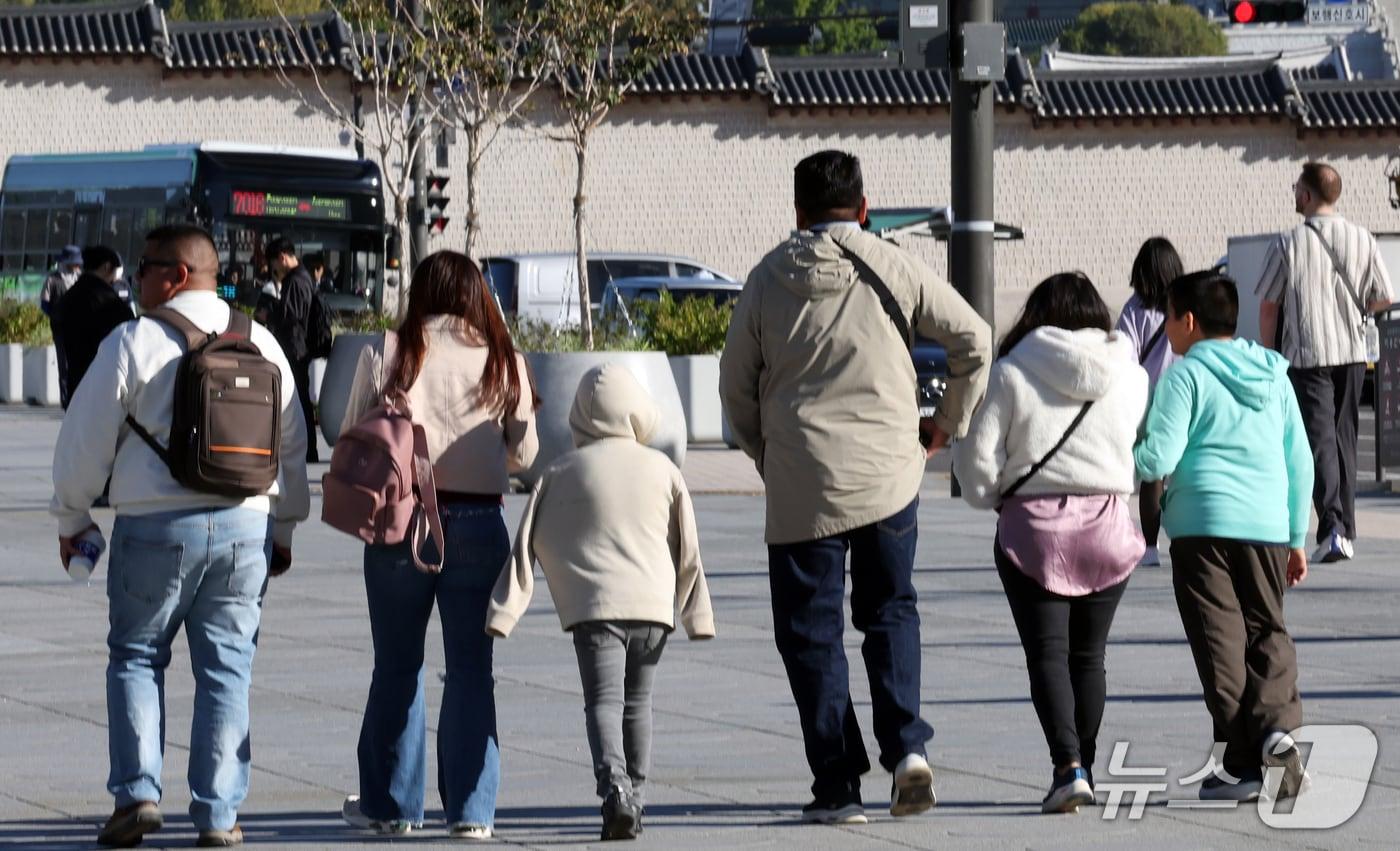 본문 이미지 - 2일 오전 서울 광화문광장에서 외국인 관광객들이 몸을 움크린 채 발걸음을 옮기고 있다. 이날 새벽 서울 지역 체감온도는 12도까지 떨어졌다. 2026.10.2 ⓒ 뉴스1 이종덕 기자