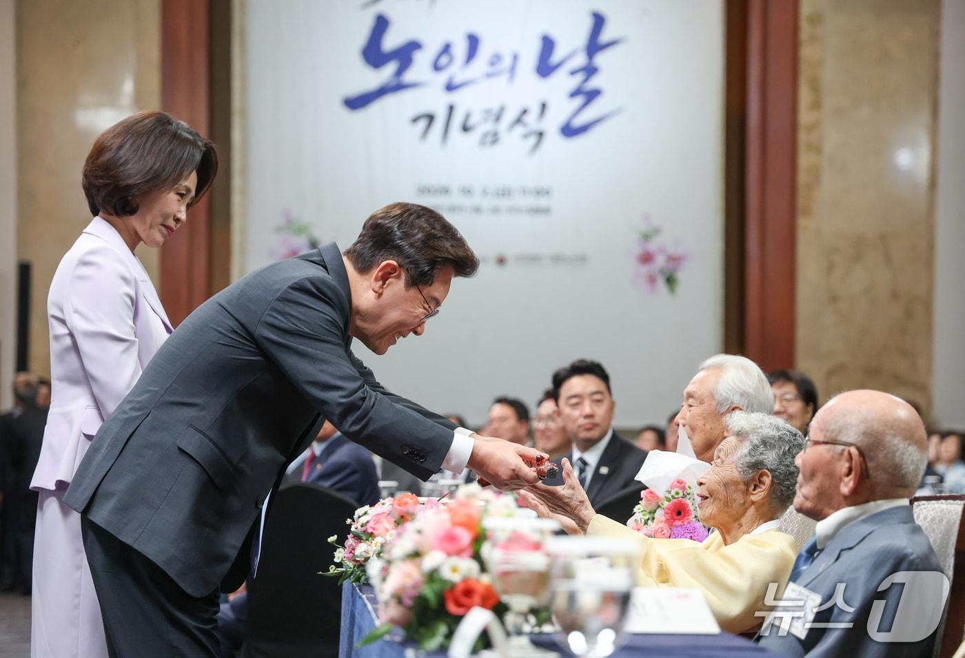 본문 이미지 - 이재명 대통령이 2일 서울 한 호텔에서 열린 제30회 노인의 날 기념식에서 어르신에게 청려장을 증정하고 있다. (청와대통신사진기자단) 2026.10.2 ⓒ 뉴스1 이재명 기자
