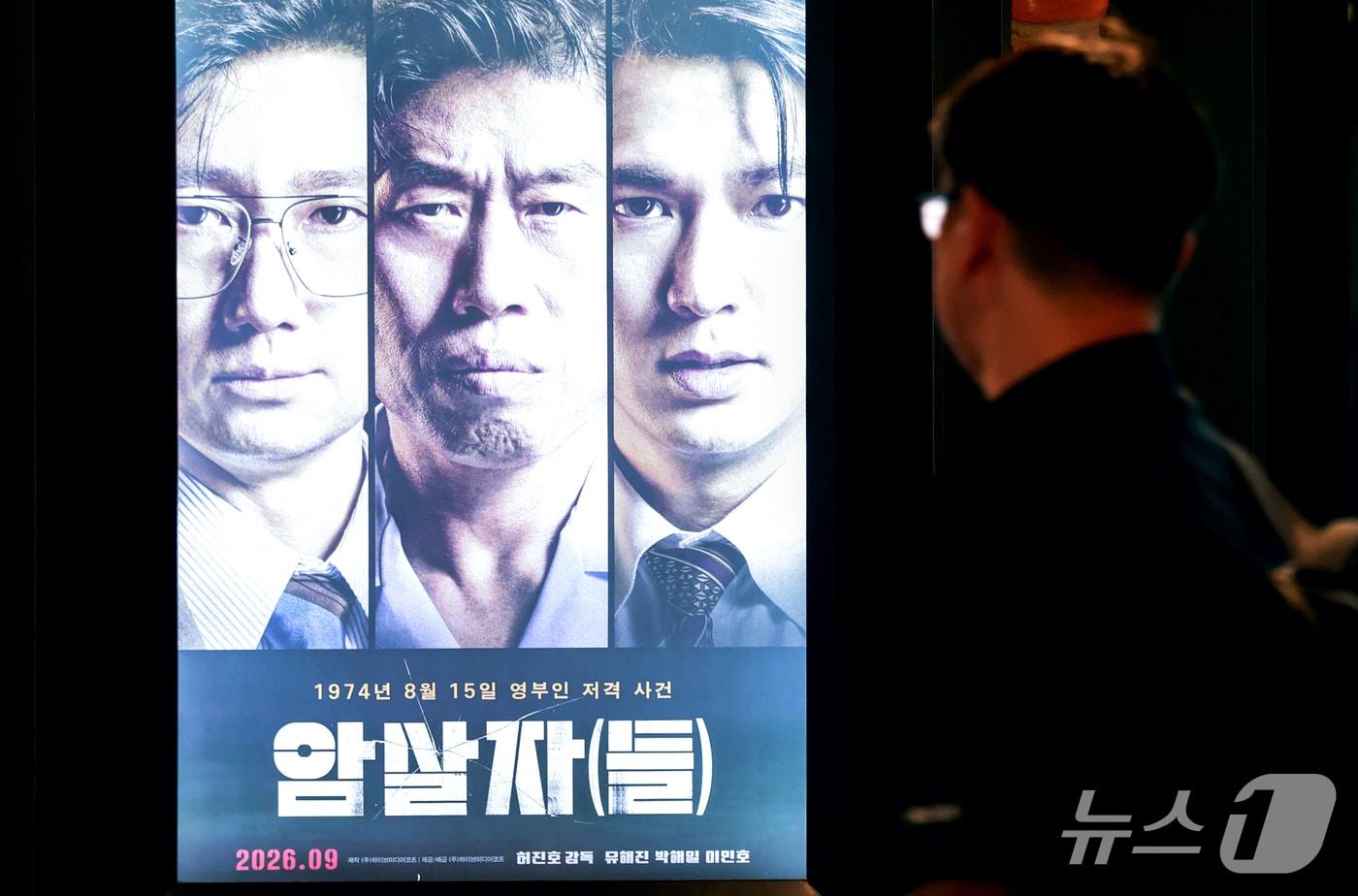 본문 이미지 - 영화 ‘암살자(들)’이 역사 왜곡을 둘러싼 정치권 논란 속에서도 전체 박스오피스 1위를 탈환하며 누적 관객 수 182만 명을 넘어선 2일 서울 시내 한 영화관에 영화 '암살자(들)' 홍보 포스터가 게시돼 있다. 2026.10.2 ⓒ 뉴스1 이호윤 기자