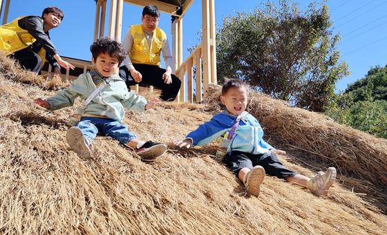 본문 이미지 - 전북 완주 고산자연휴양림 일원에서 열린 '제14회 완주와일드&로컬푸드축제'를 찾은 어린이들이 볏짚 미끄럼틀을 즐기고 있다. (완주군 제공. 재판매 및 DB 금지) ⓒ 뉴스1
