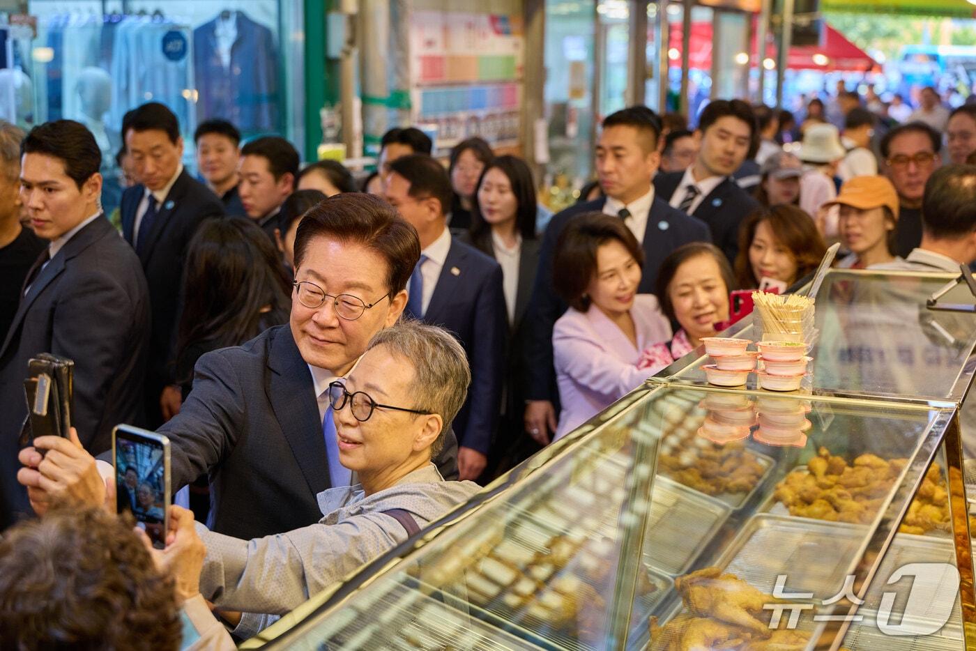 본문 이미지 - 이재명 대통령과 김혜경 여사가 지난 2일 서울 서대문구 영천시장을 찾아 시민들과 기념촬영을 하고 있다. (청와대 제공. 재판매 및 DB 금지) 2026.10.2 ⓒ 뉴스1 이재명 기자