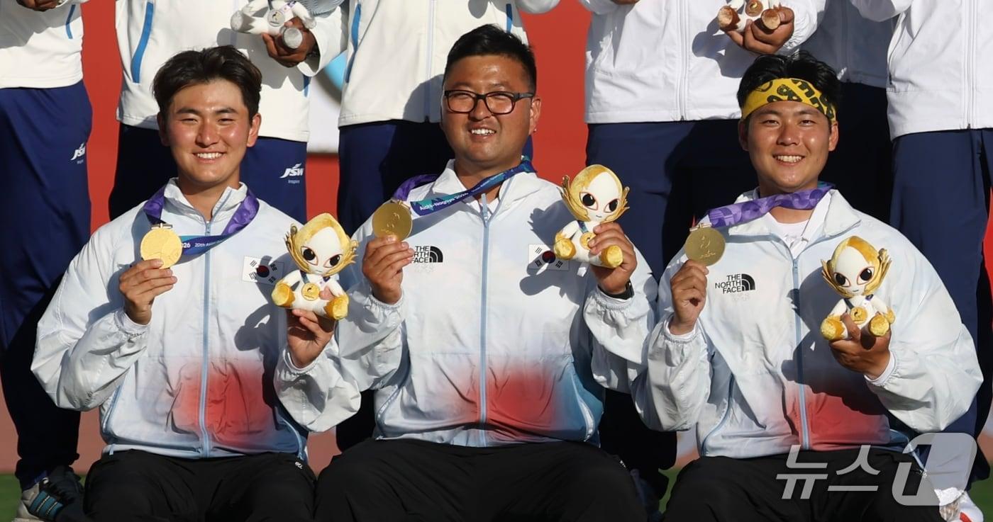 본문 이미지 - 대한민국 김제덕(왼쪽부터), 김우진, 이우석이 2일 일본 오카자키 중앙종합공원 다목적광장에서 열린 2026 아이치·나고야 아시안게임 양궁 리커브 남자 단체전 결승 시상식에서 기뻐하고 있다. 2026.10.2 ⓒ 뉴스1 김민지 기자