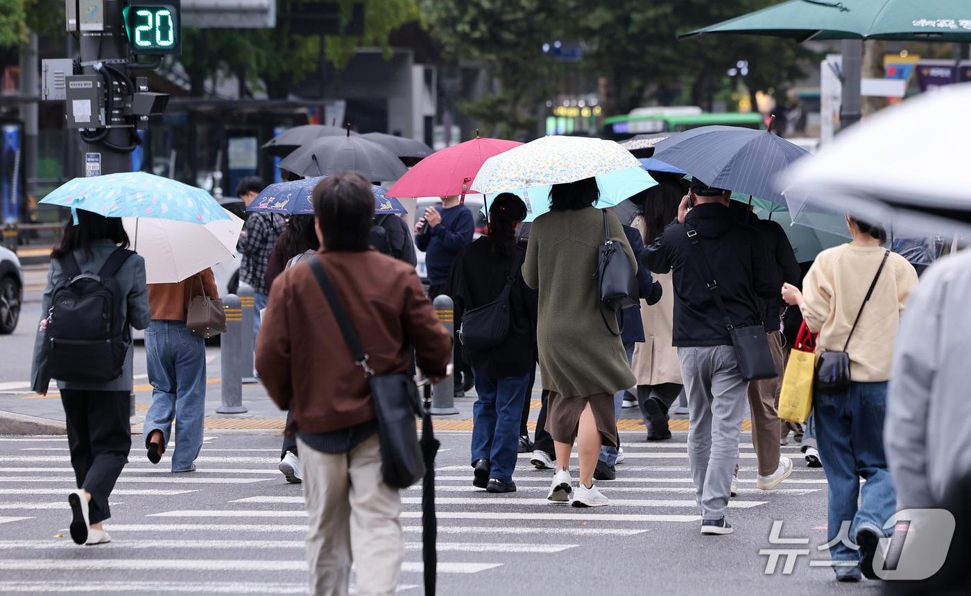 본문 이미지 - 가을비가 내리는 21일 서울 종로구 광화문네거리에서 우산을 쓴 시민들이 출근길을 서두르고 있다. 2026.10.21 ⓒ 뉴스1 김성진 기자