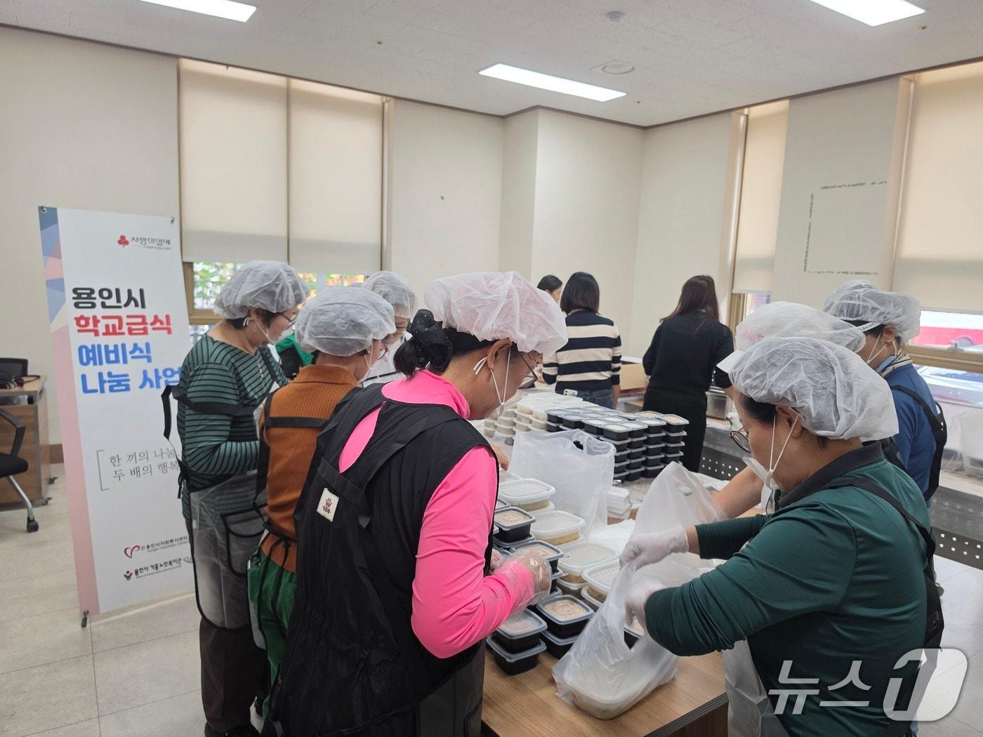 본문 이미지 - 용인시 '학교급식 예비식 나눔 시범사업' 참여자들이 급식을 용기에 담고 있는 모습.(용인시 제공)