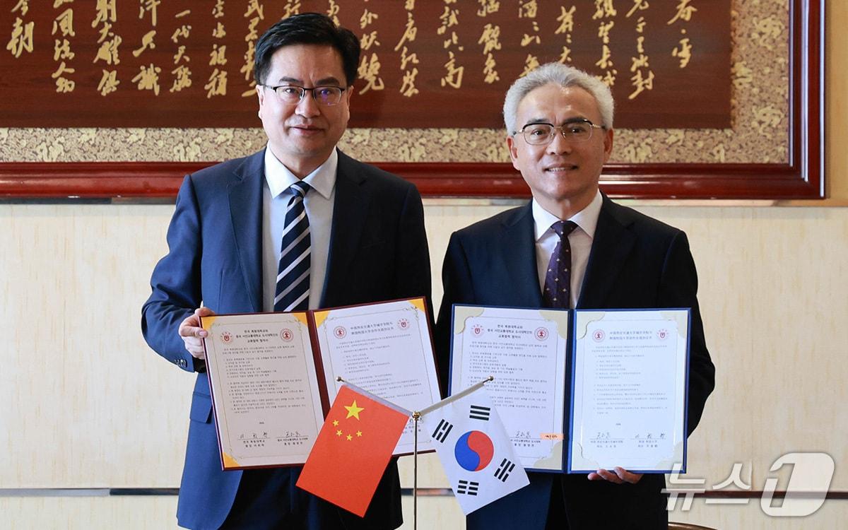 본문 이미지 - 중국 서안교통대학교 도시대학에서 열린 국제교류 협력 협약식에서 이희학 총장(오른쪽)과 왕융취안 서안교통대 총장이 협약서를 들고 기념촬영을 하고 있다. (목원대 제공. 재판매 및 DB금지) /뉴스1
