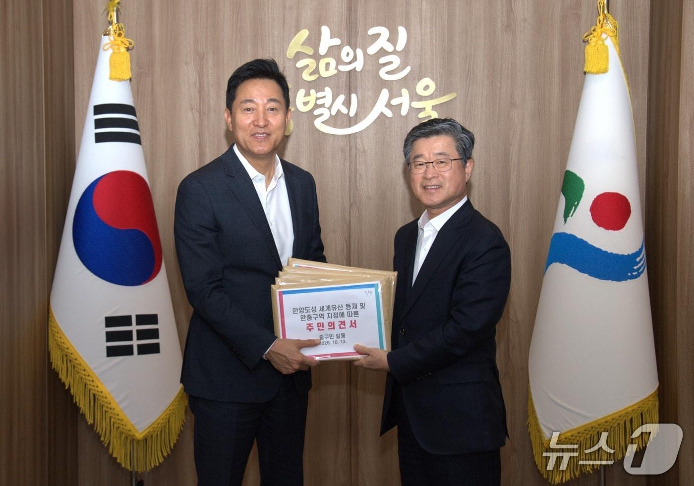 본문 이미지 - 김길성 중구청장이 오세훈 서울시장과 주민 의견서를 전달하기 위해 만나고 있다.