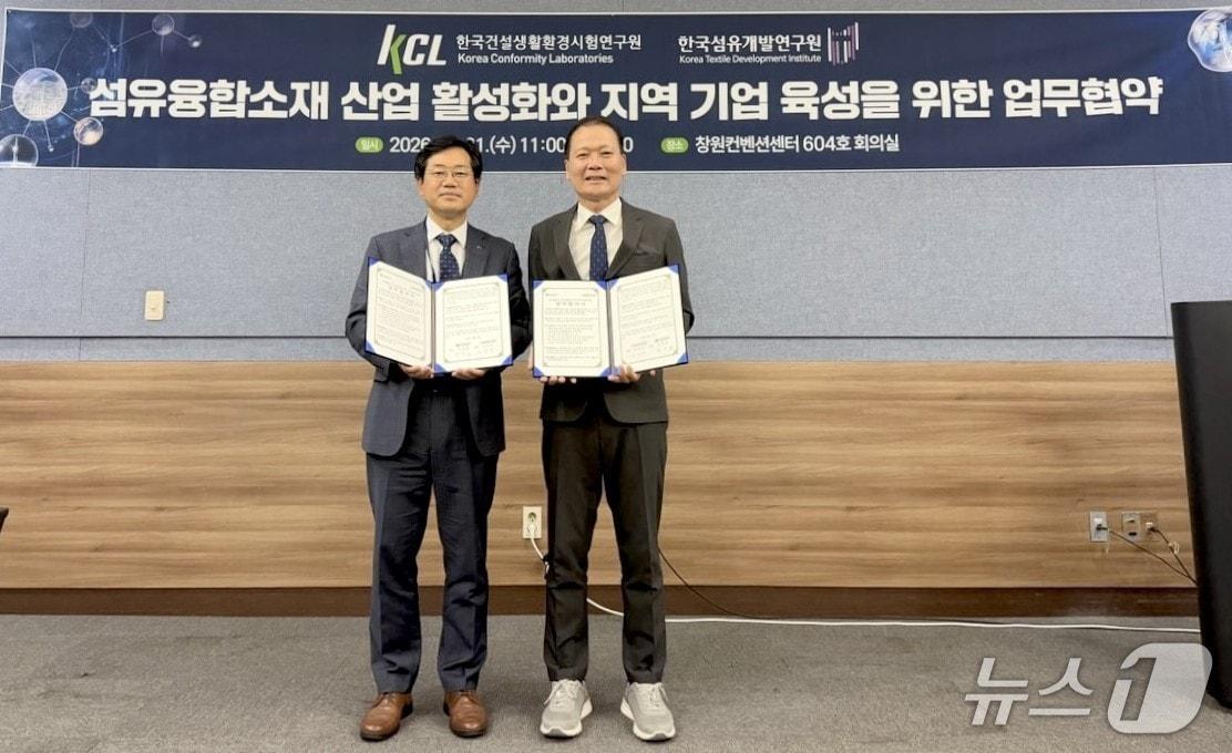 본문 이미지 - 김성만 한국섬유개발연구원장(오른쪽)과 천영길 한국건설생활환경시험연구원장이 첨단 섬유융합소재 산업 활성화 및 지역기업 경쟁력 강화를 위한 업무협약을 체결한 뒤 협약서를 펼쳐 보이고 있다.(섬유개발연구원 제공, 재판매 및 DB 금지)
