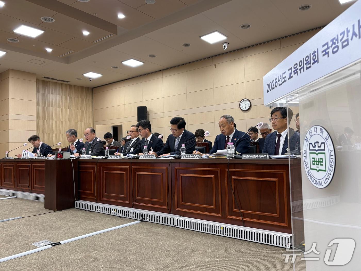 본문 이미지 - 21일 부산대학교에서 열린 국회 교육위원회의 부산대학교·경상국립대학교·경북대학교·강원대학교·부경대학교·한국해양대학교·부산교육대학교·창원대학교·진주교육대학교에 대한 국정감사에서 대학 총장들이 의원들의 질의를 듣고 있다. 2026.10.21 ⓒ 뉴스1 박서현 기자