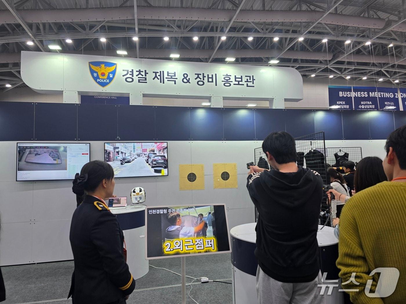 본문 이미지 - 21일 인천 송도컨벤시아에서 '2026 국제치안산업대전 관람객이 저위험 권총을 체험해 보고 있다.