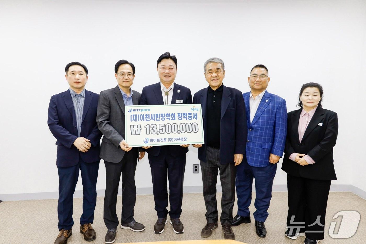 본문 이미지 - 하이트진로 관계자들이 성수석 시장(왼쪽 세 번째)에게 장학금을 전달하고 있는 모습.(이천시 제공)