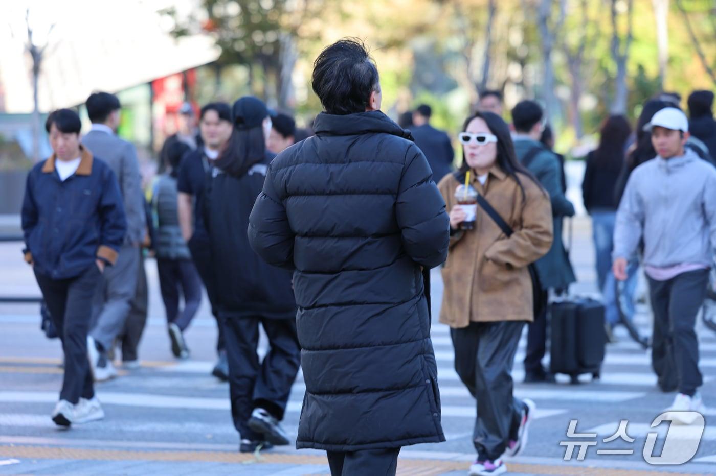 본문 이미지 - 서울 아침 5도로 기온이 큰 폭으로 떨어진 22일 오전 서울 종로구 광화문 네거리에서 롱패딩을 입은 시민이 발걸음을 옮기고 있다. 2026.10.22 ⓒ 뉴스1 안은나 기자