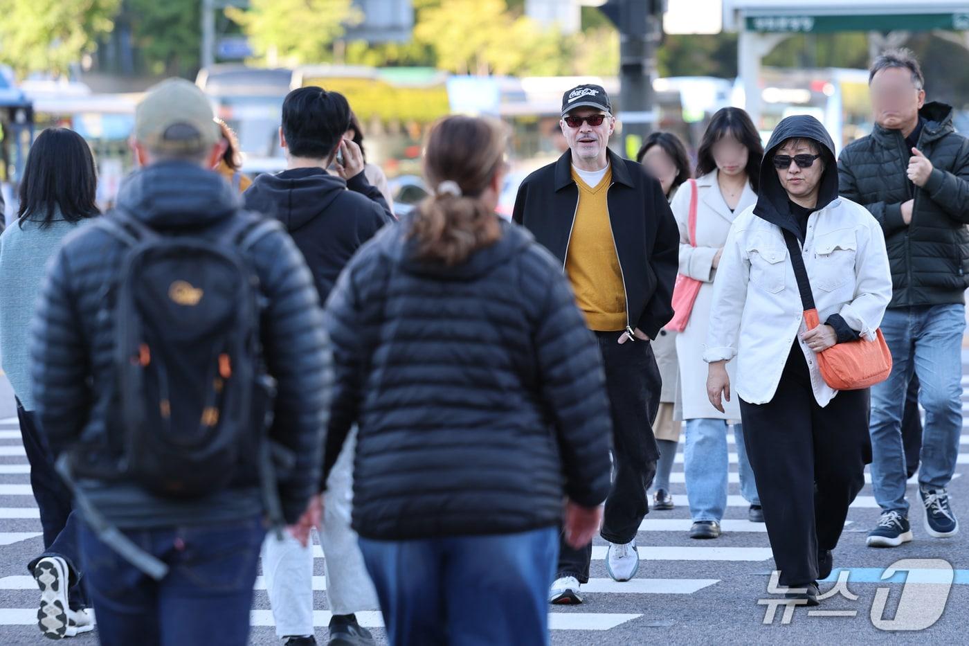 본문 이미지 - 서울 아침 5도로 기온이 큰 폭으로 떨어진 22일 오전 서울 종로구 광화문 네거리에서 패딩을 입은 외국인 관광객들이 발걸음을 옮기고 있다. 2026.10.22 ⓒ 뉴스1 안은나 기자
