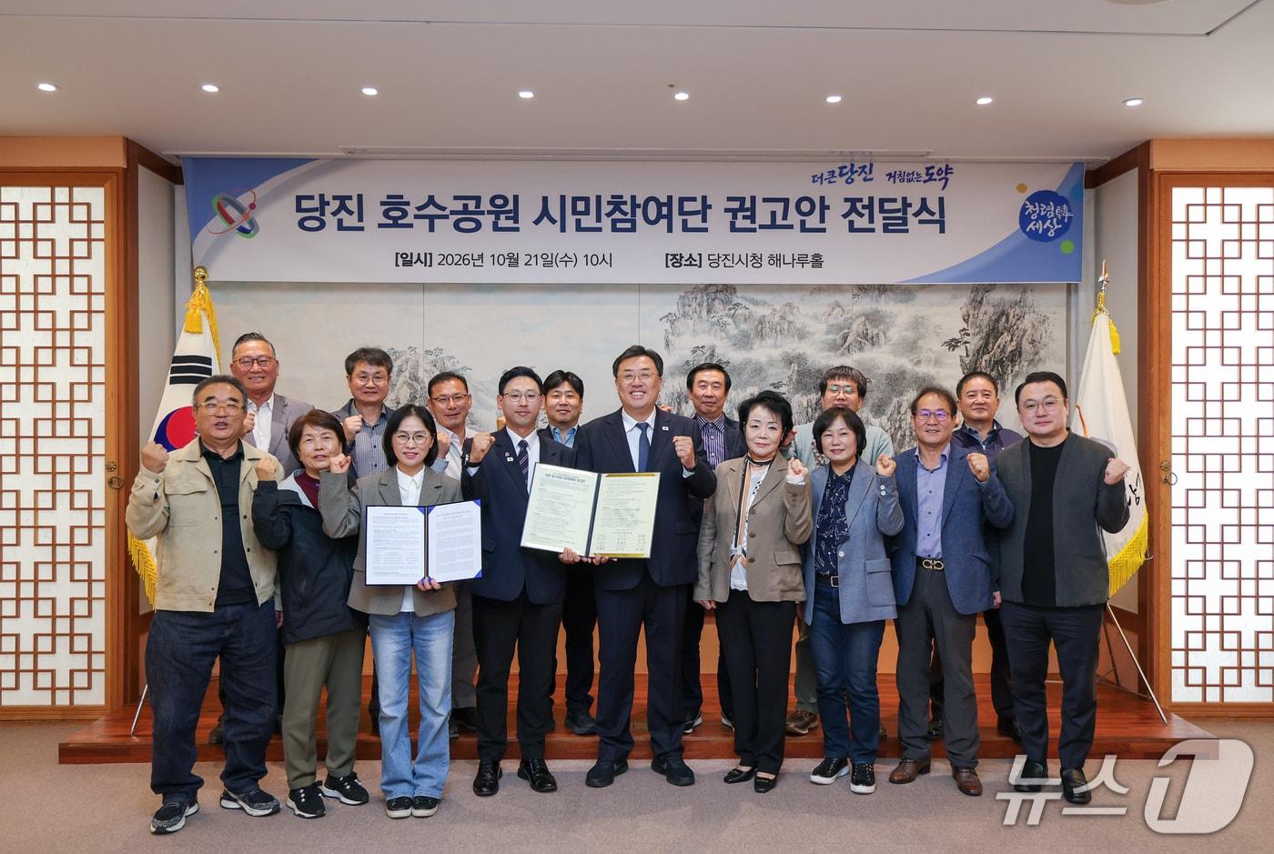 본문 이미지 - 지난 21일 충남 당진시청 해나루홀에서 열린 '당진 호수공원 시민참여단 권고안 전달식'에서 김기재 당진시장(앞줄 가운데)과 시민참여단 관계자들이 권고안을 전달한 뒤 기념촬영을 하고 있다.(당진시 제공. 재판매 및 DB 금지)