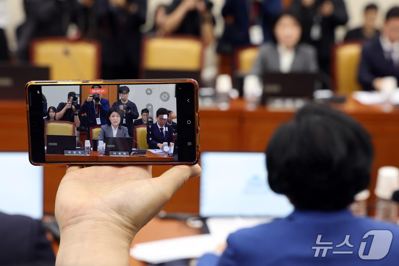 본문 이미지 - 이진숙 의원 보좌진이 22일 서울 여의도 국회 과학기술정보방송통신위원회에서 열린 방송미디어통신위원회 등에 대한 국정감사 종합감사에서 휴대폰을 이용해 촬영하고 있다. 2026.10.22 ⓒ 뉴스1 황기선 기자