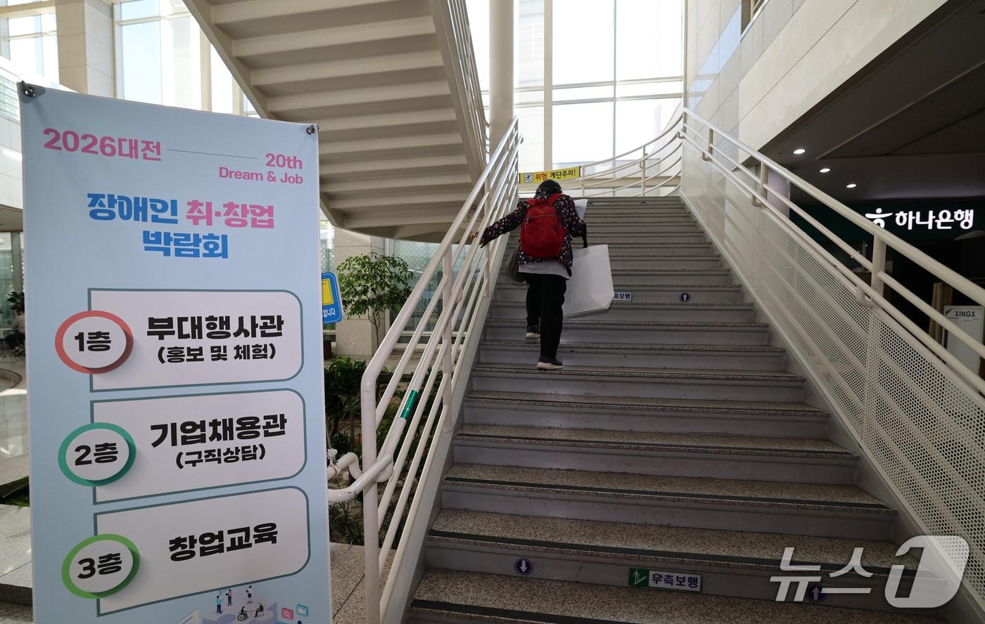 본문 이미지 - 22일 대전시청에서 열린 2026 대전 장애인 취·창업 박람회에 참가한 구직자가 상담을 받기 위해 계단을 오르고 있다. 2026.10.22 ⓒ 뉴스1 김기태 기자