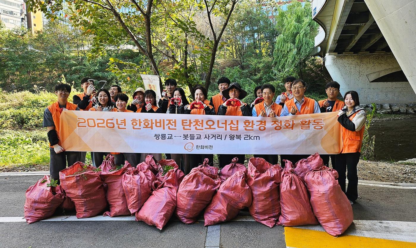 본문 이미지 - 한화비전 임직원들이 지난 21일 성남시 분당구 운중천 일대에서 생물다양성 보전을 위한 '유해식물 제거' 봉사활동을 진행하고 기념 촬영을 하고 있다. (한화비전 제공)