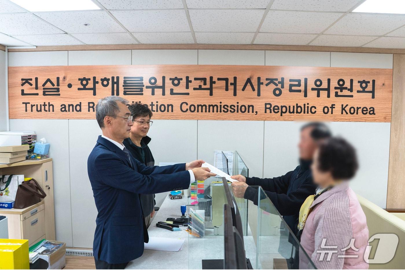 본문 이미지 - 이은용 진실화해위원 대외협력담당관(왼쪽 첫 번째)이 23일 서울 중구 진실화해위원회 민원실에서 1만 번째 진실규명 신청 접수를 받고 있다. (진실화해위 제공. 재판매 및 DB 금지)