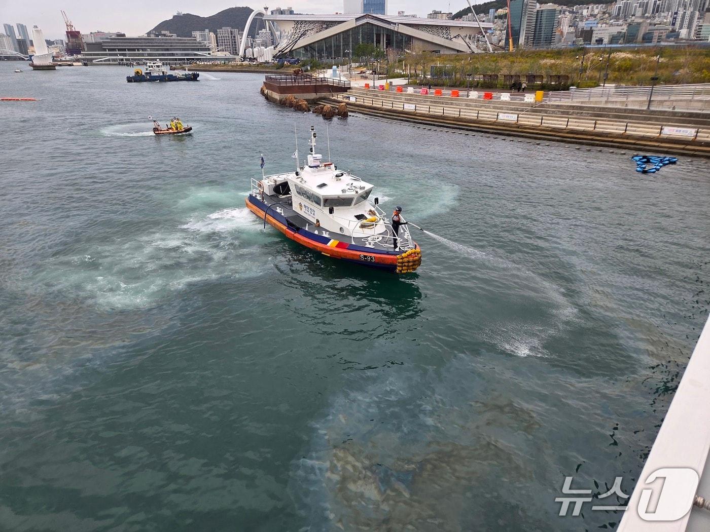 본문 이미지 - 23일 북항친수공원 인공수로 제6보도교 인근 방향에서 발견된 기름띠를 제거하고 있는 해경 (해경 제공. 재판매 및 DB 금지)