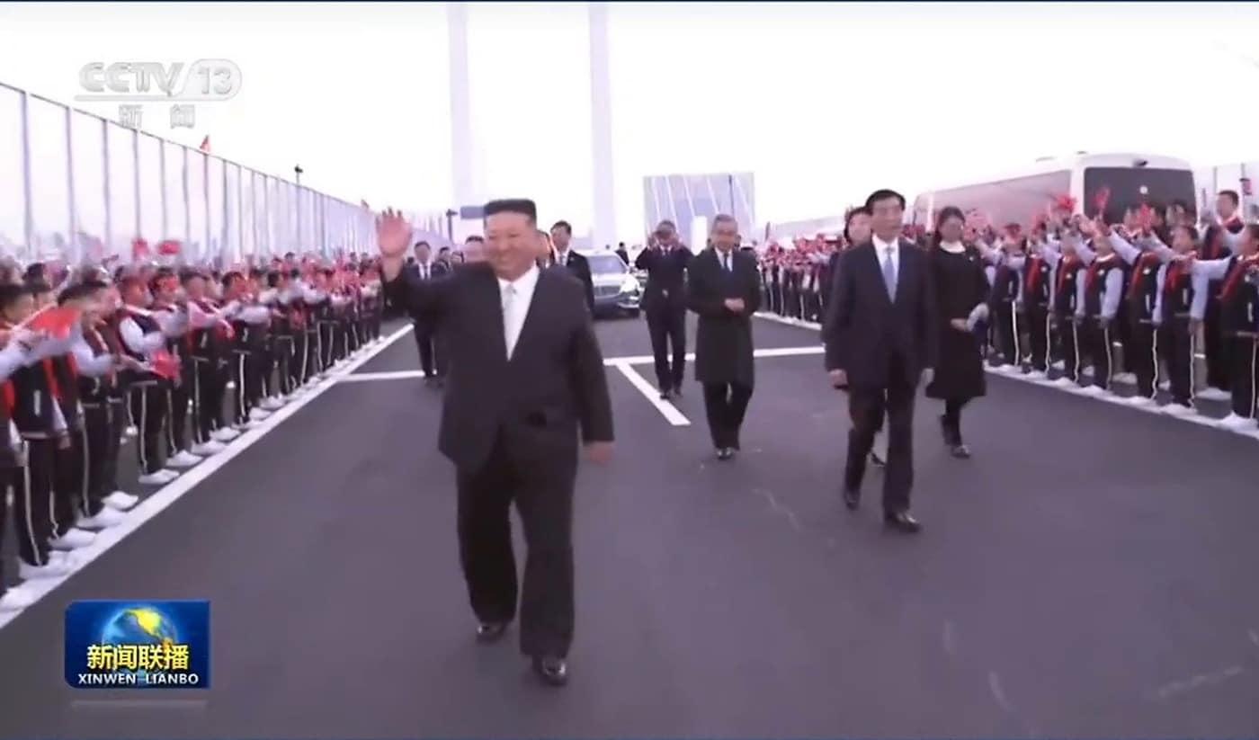 본문 이미지 - 김정은 북한 노동당 총비서가 24일 중국 랴오닝성 단둥을 방문한 가운데, 신압록강대교에서 환영 인파를 향해 손을 흔들며 이동하고 있다. 김 총비서의 단둥 방문에는 왕후닝 중국공산당 중앙정치국 상무위원 겸 전국인민정치협상회의(정협) 주석이 동행했다. (중국 CCTV 화면 캡처)
