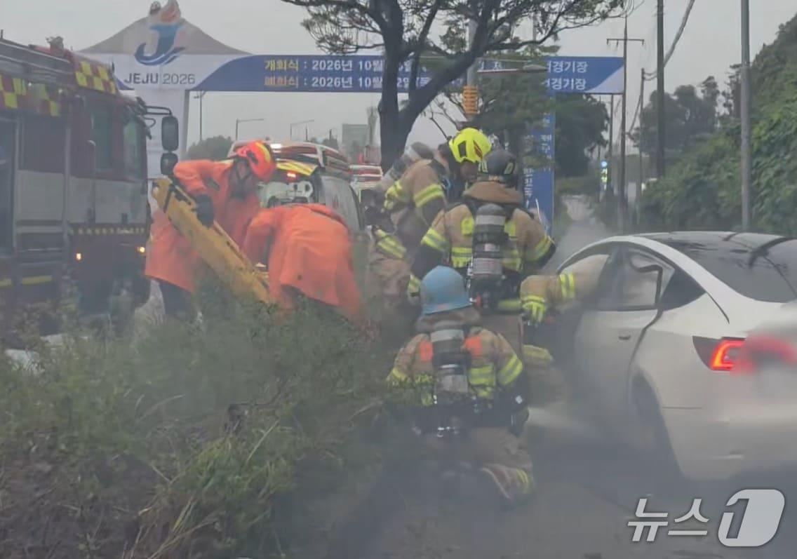 본문 이미지 - 지난 24일 오후 제주시 화북2동 번영로에서 전기차가 가로등과 충돌한 후 운전자가 갇혀 구조작업이 진행되는 모습.(제주도소방안전본부 제공. 재판매 및 DB 금지)