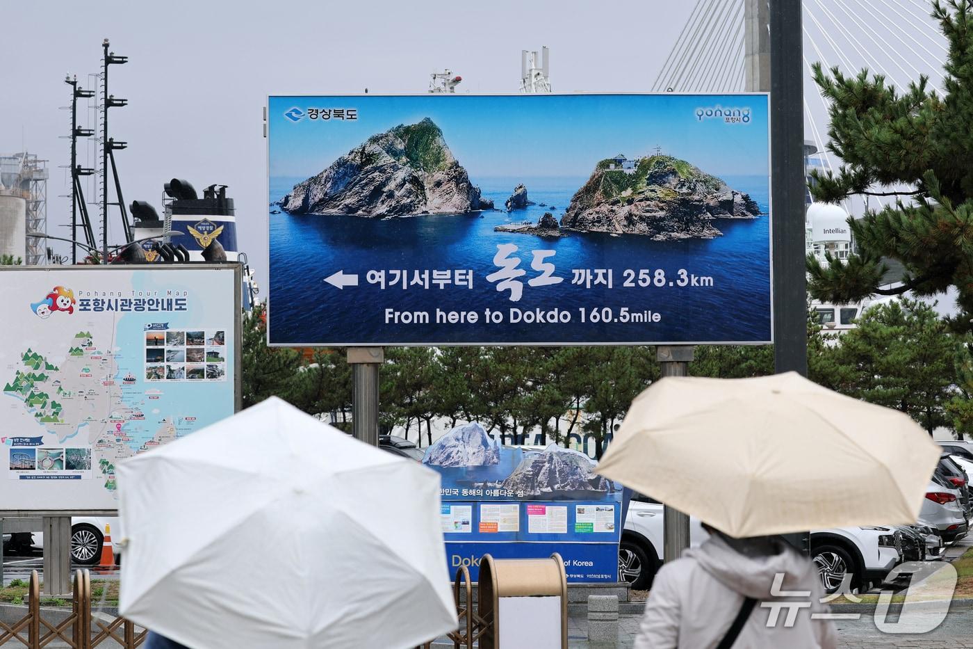 본문 이미지 - 독도의 날인 25일 경북 포항시 북구 여객선터미널 앞에서 관광객들이 독도 표지판을 지켜보고 있다. 10월 25일은 1900년 고종 황제가 대한제국 칙령 제41호를 통해 독도를 울릉도 관할 구역에 명시한 사실을 기념하는 날이다. 2026.10.25 ⓒ 뉴스1 최창호 기자