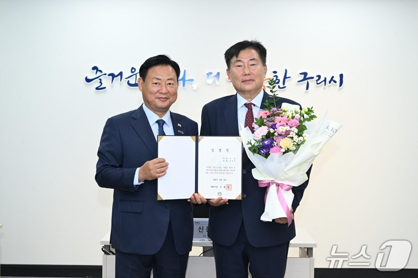 본문 이미지 - 신동화 구리시장(왼쪽)이 이승우 구리도시공사 신임 사장에게 임명장을 전달하는 모습. (구리시 제공)