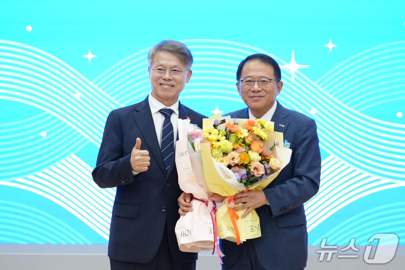 본문 이미지 - 강명수 전남광주통합특별시 산업경제부시장이 26일 동부청사 이순신강당에서 열린 ‘초대 산업경제부시장 취임식’에서 취임축하 꽃다발을 받고 민형배 전남광주통합시장과 기념촬영을 하고 있다.(전남광주통합특별시 제공. 재판매 및 DB금지) 2026.10.26 /뉴스1