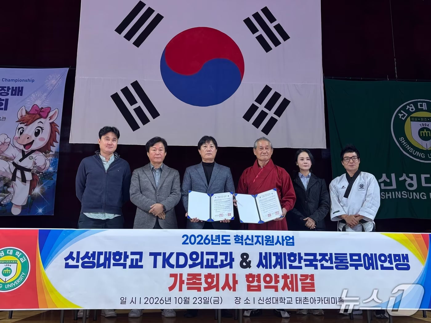 본문 이미지 - 지난 23일 충남 당진 신성대학교 태촌아카데미홀에서 열린 신성대 TKD외교과와 세계한국전통무예연맹의 업무협약식에서 양 기관 관계자들이 협약서를 들고 기념촬영을 하고 있다.(신성대 제공. 재판매 및 DB 금지)