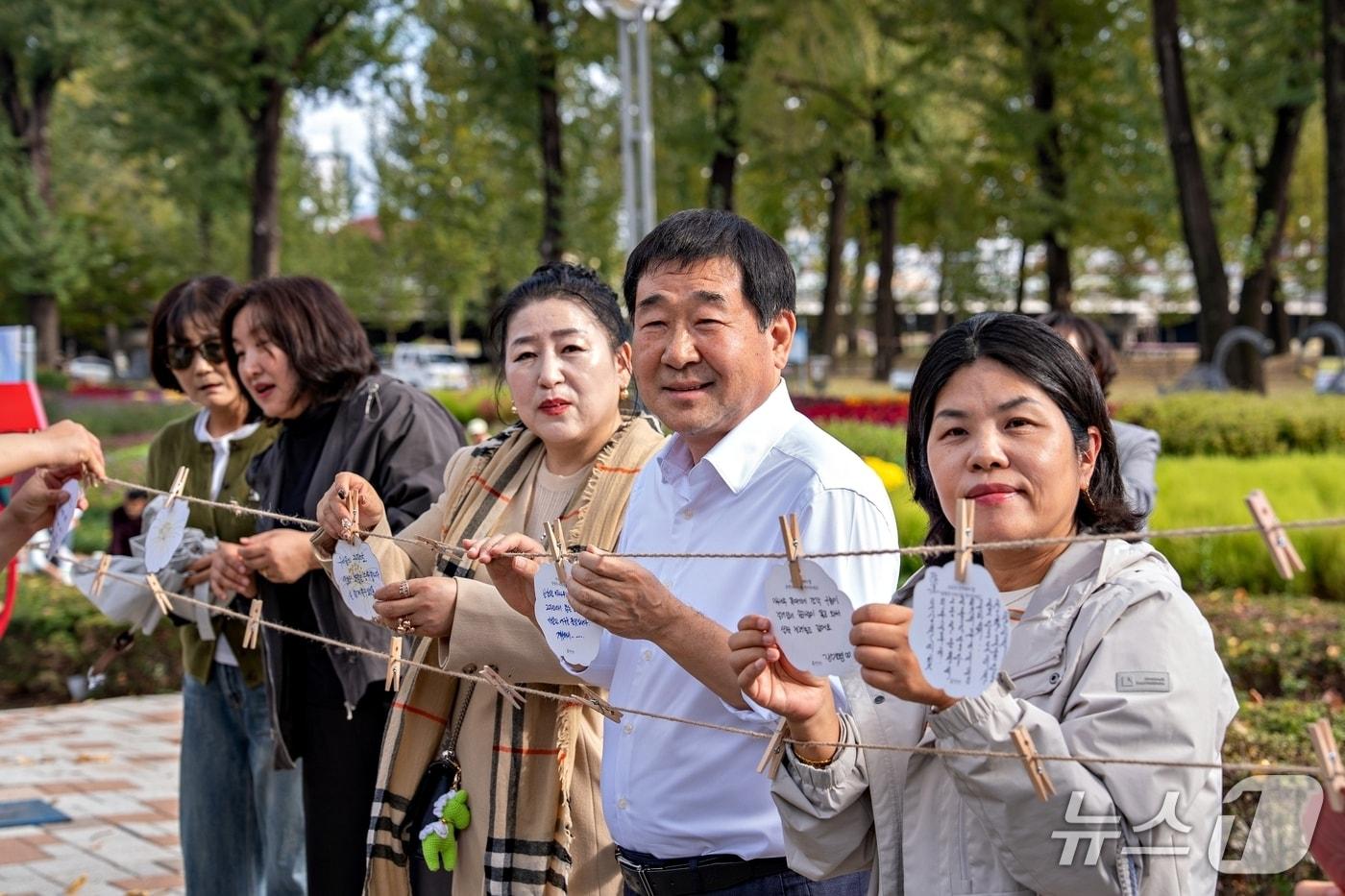 본문 이미지 - 26일 열린 증평 보강천 미루나무숲 기념행사에서 이재영 군수 등이 추억 기록표를 달고 있다.(증평군 제공. 재판매 및 DB 금지).2026.10.26/뉴스1
