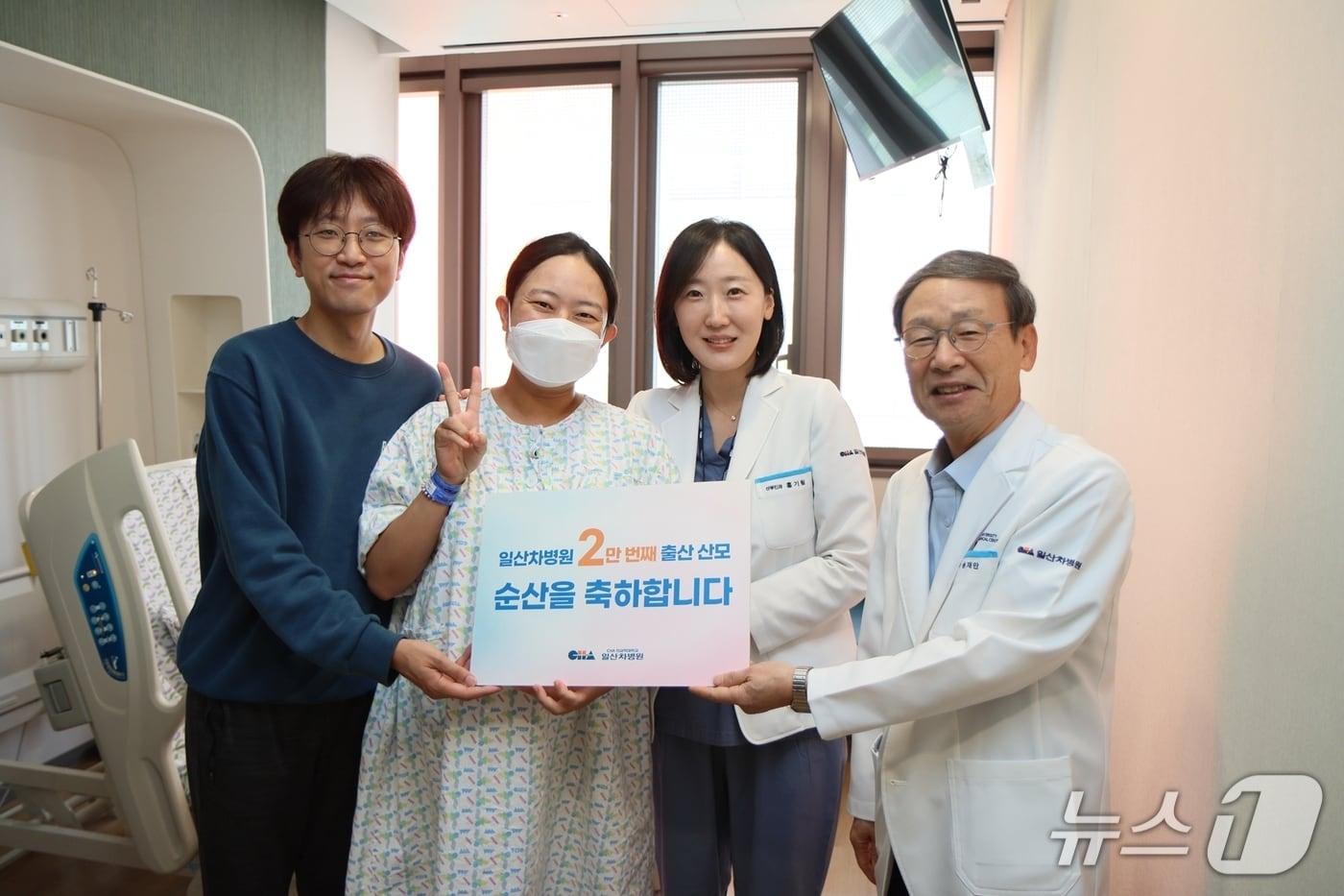 본문 이미지 - 송재만 차 의과학대 일산차병원 병원장(가장 오른쪽)과 주치의 홍기림 교수가 2만 번째 출산 산모와 가족에게 축하 선물을 전달하고 있다.(차 의과학대 일산차병원 제공)