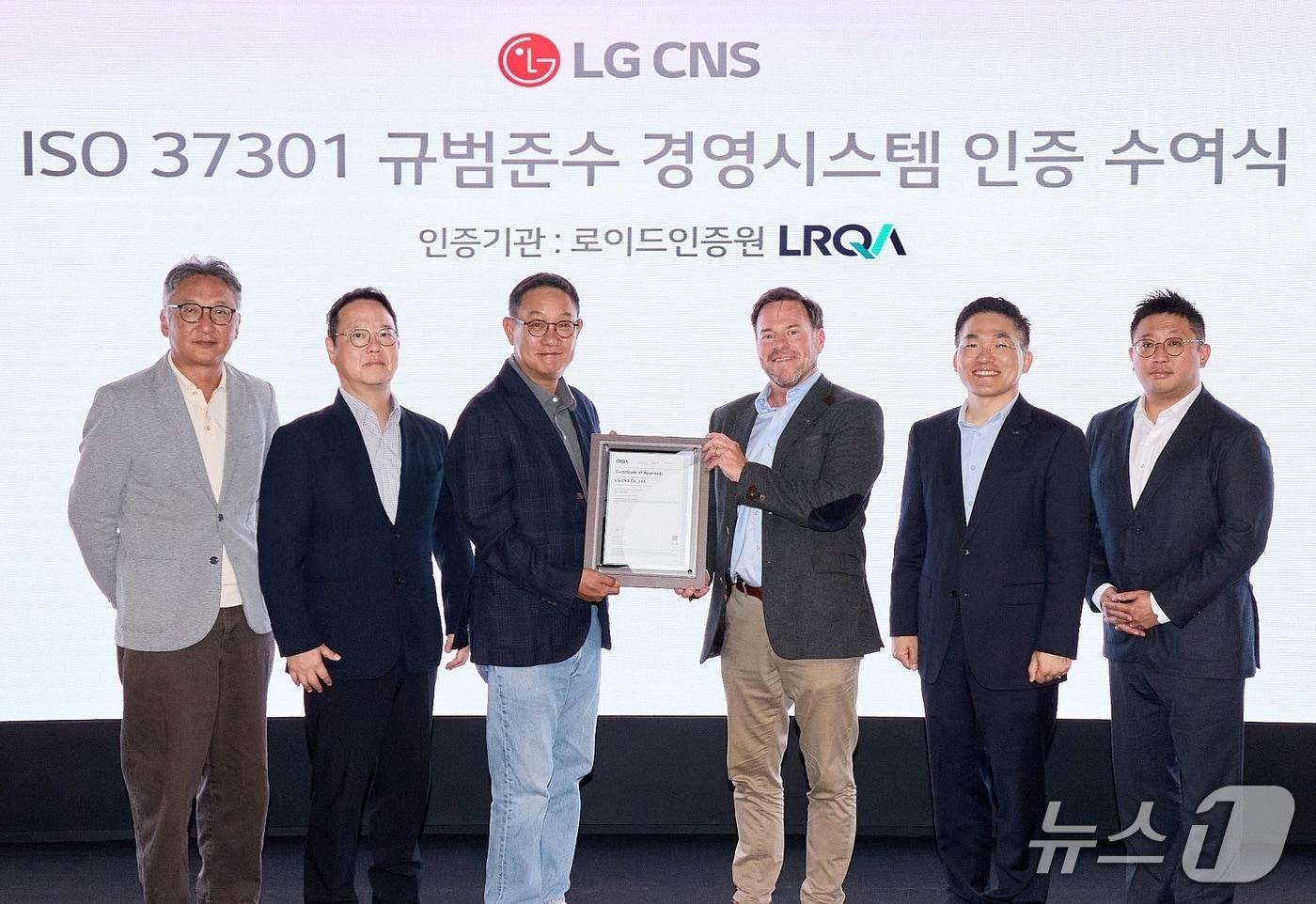 본문 이미지 - 현신균 LG CNS CEO와(왼쪽에서 세번째)과 스튜어트 켈리 로이드인증원 글로벌커머셜어드바이저(오른쪽에서 세번째) 및 관계자들이 인증 수여식에서 사진 촬영하는 모습.(LG CNS 제공, 재판매 및 DB 금지)