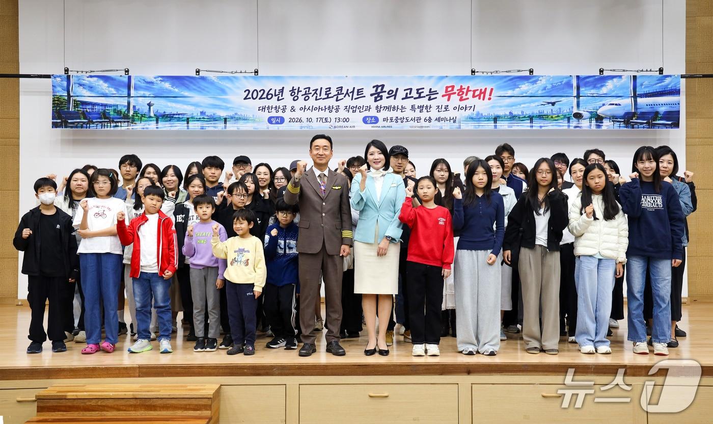 본문 이미지 - 서울 마포구 마포중앙도서관에서 열린 직업 특강에 참석한 청소년들이 대한항공·아시아나항공 운항·객실 승무원과 함께 기념 촬영을 하고 있다.(대한항공 제공) 2026.10.17.