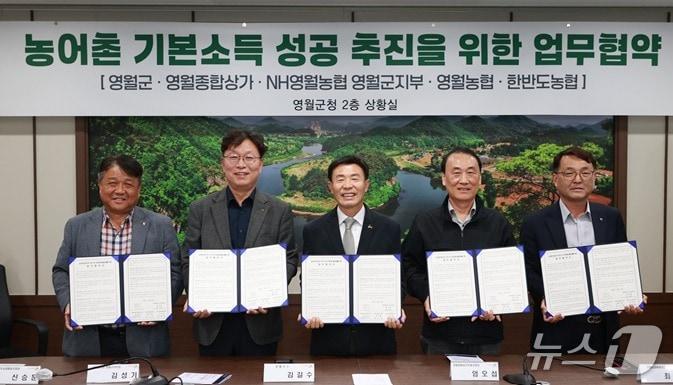 본문 이미지 - 강원 영월군이 27일 군청에서 영월군종합상가·농협중앙회 영월군지부·영월농업협동조합, 한반도농업협동조합과 농어촌기본소득 시범사업 유치를 위한 업무협약을 맺었다. (영월군 제공. 재판매 및 DB 금지) 2026.10.27/뉴스1