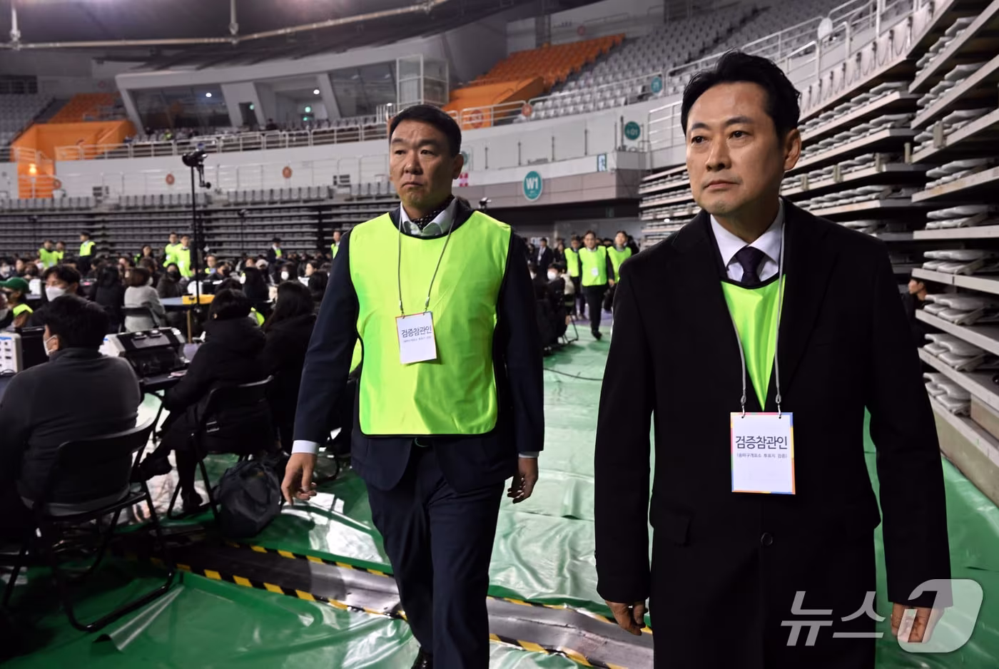 본문 이미지 - 장동혁 국민의힘 대표와 국민의힘 검증참관인이 28일 오전 서울 송파구 올림픽공원 핸드볼경기장에서 열린 선거관리위원회 특검의 투표용지 현장 검증에서 이태한 선거관리위원회 특별검사와 대화를 나누기 위해 이동하고 있다. 2026.10.28 ⓒ 뉴스1 사진공동취재단