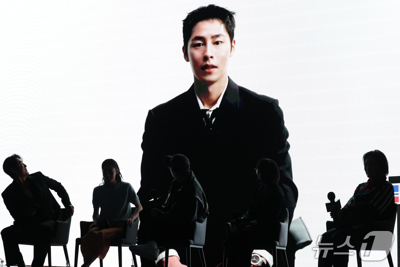 본문 이미지 - 군복무 중인 배우 이재욱이 28일 서울 영등포구 페어몬트 앰배서더 서울에서 열린 넷플릭스 시리즈 '꿀알바' 제작발표회에서 영상으로 인사를 전하고 있다. '꿀알바'는 시급 50배부터 시작하는 ‘꿀알바’만을 소개하는 수상한 인력사무소를 배경으로, 청년 혁준(이재욱 분)이 악몽 같은 노동 현장에 투입되면서 펼쳐지는 생계형 밥벌이 호러 시리즈다. 2026.10.28 ⓒ 뉴스1 권현진 기자