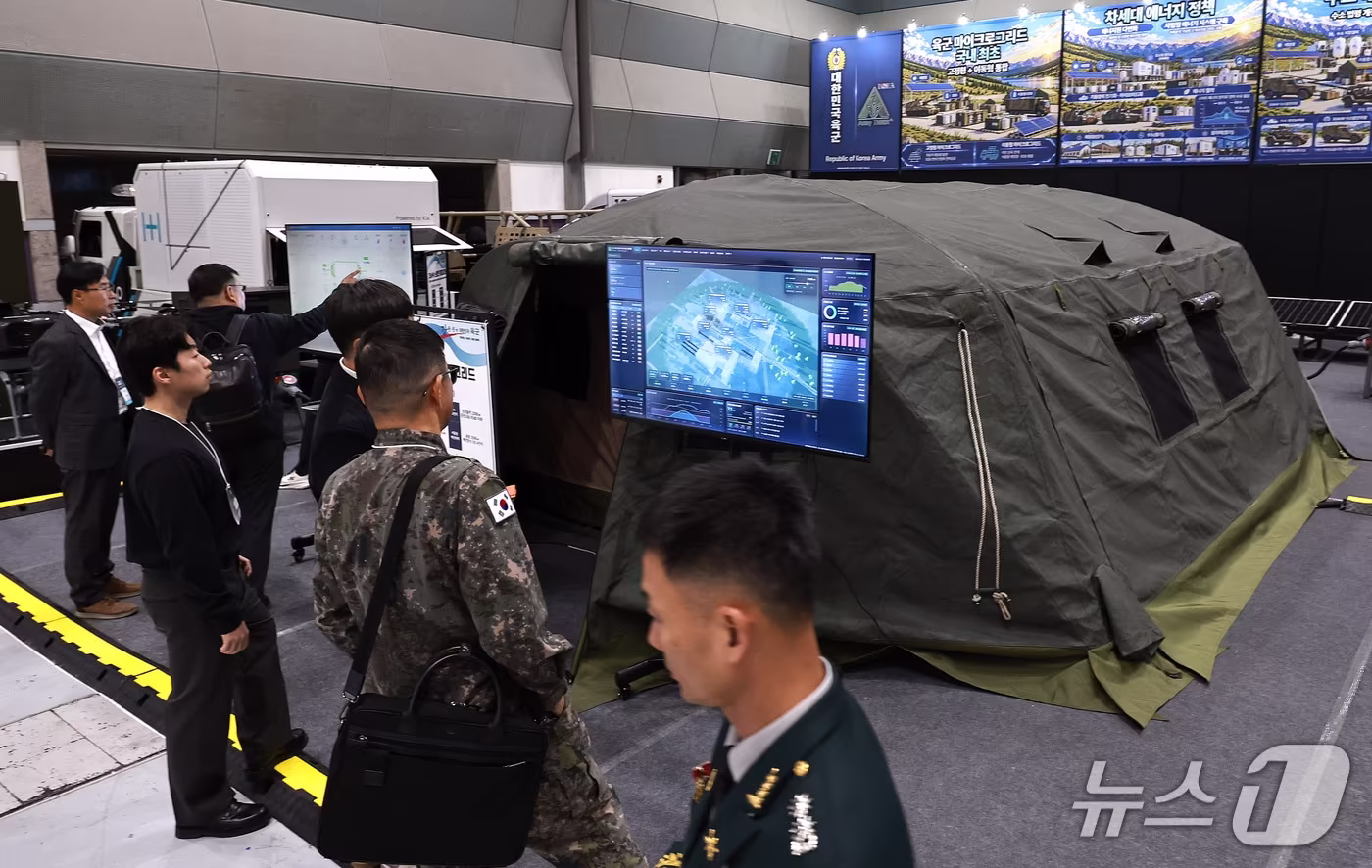 본문 이미지 - 28일 서울 강남구 코엑스에서 열린 '스마트에너지플러스2026'에서 관람객들이 육군의 이동식 발전기를 모듈로 연결해 전력망을 구성하는 '이동형 마이크로그리드'를 살펴보고 있다. 2026.10.28 ⓒ 뉴스1 구윤성 기자