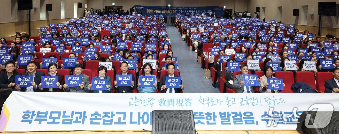 본문 이미지 -  경기 수원시 경기도교통연수원에서 열린 '찾아가는 교육감실' 타운홀 미팅에서 학부모와 참석자들이 '폰 끄고 라스' 문구가 적힌 손팻말을 들고 기념촬영을 하고 있다. (경기도교육청 제공)