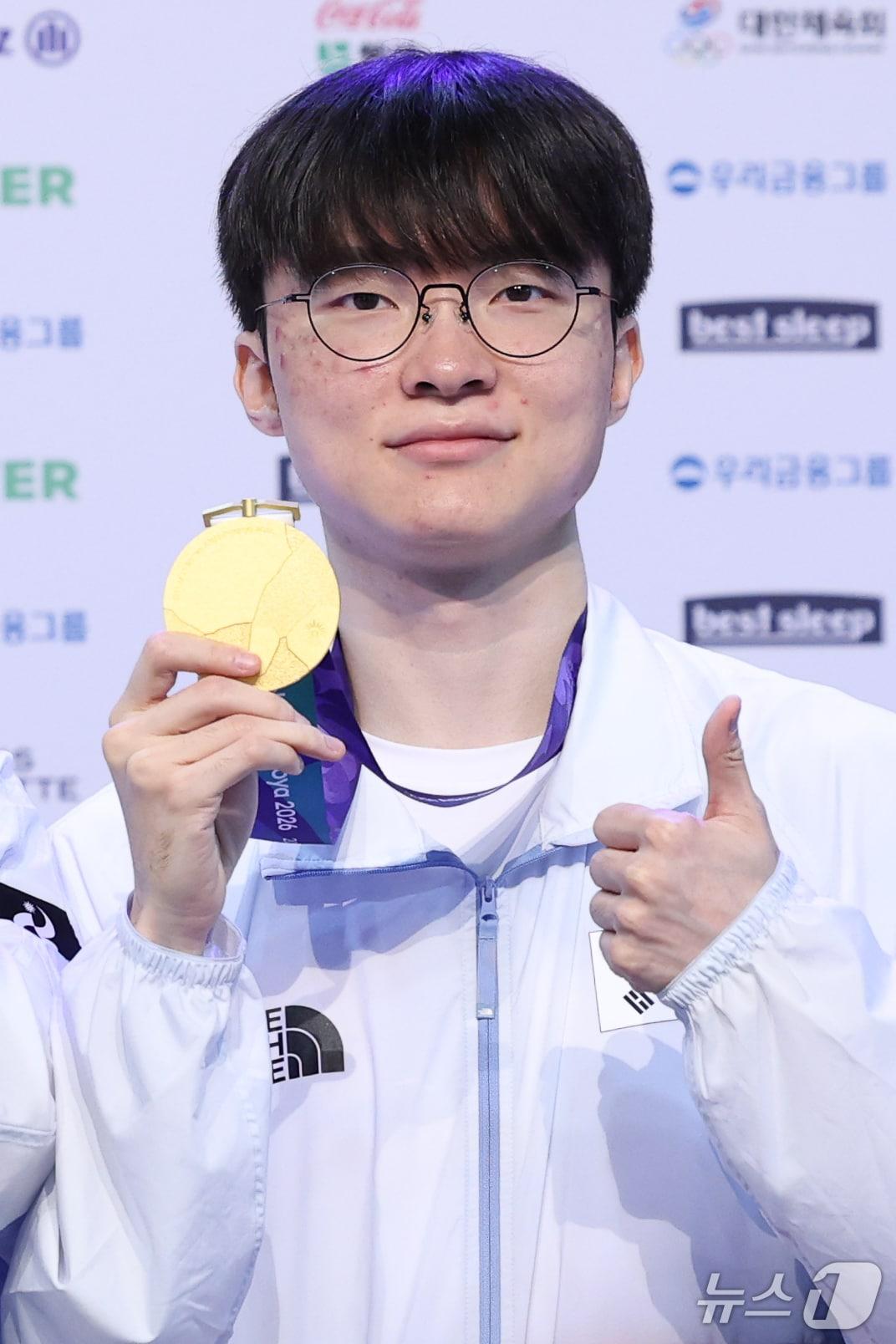 본문 이미지 - e스포츠 롤(리그오브레전드, LoL) 국가대표 '페이커' 이상혁이 3일 일본 라이브스 나고야에서 열린 2026 아이치·나고야 아시안게임 금메달리스트 기자회견에서 금메달을 들어 보이고 있다. 2026.10.3 ⓒ 뉴스1 안은나 기자