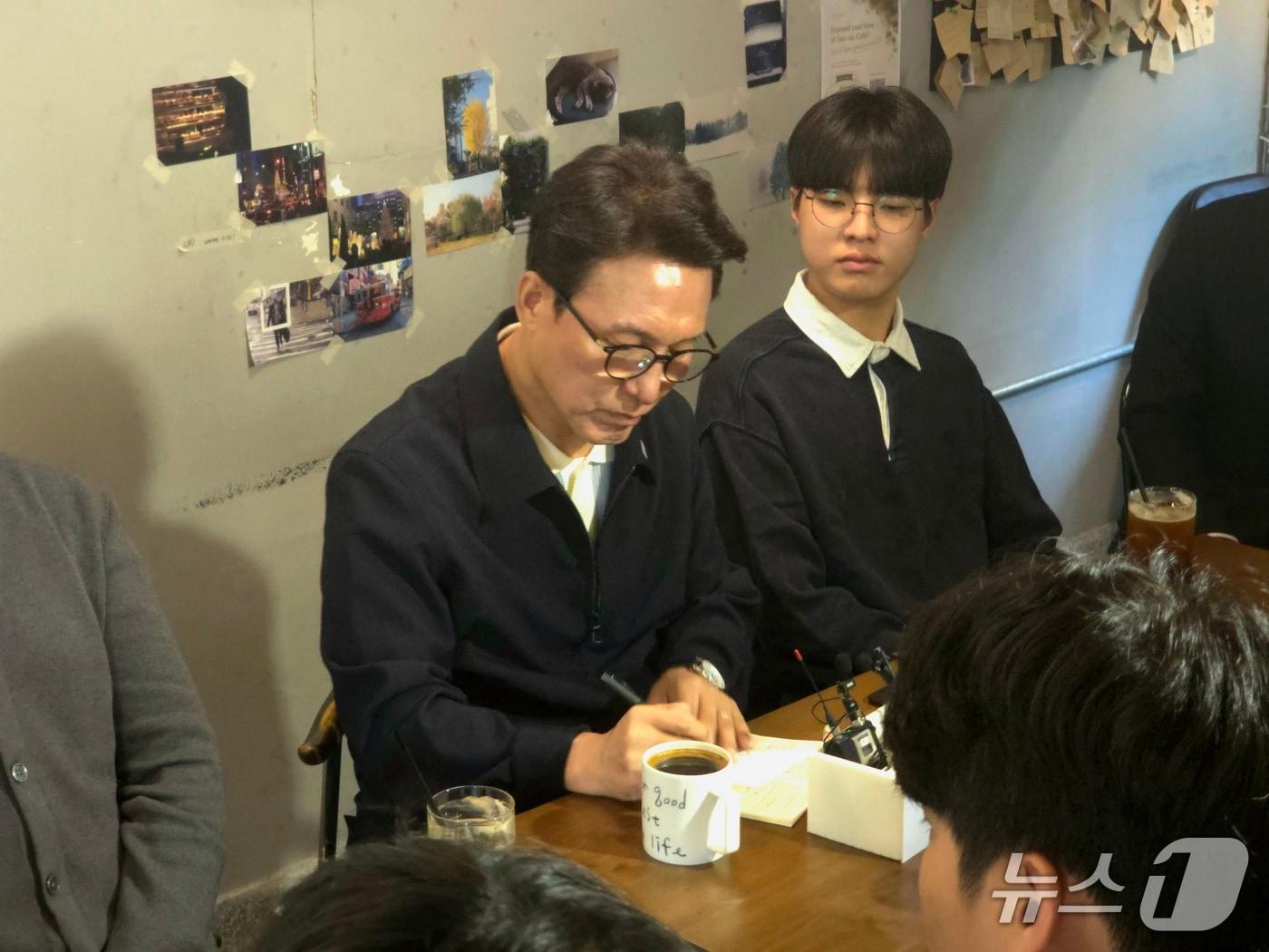 본문 이미지 - 김민석 더불어민주당 대표가 3일 부산 부산진구의 한 카페에서 가진 청년 간담회에서 참석자의 발언을 메모하고 있다. 2026.10.3 ⓒ 뉴스1 이주현 기자