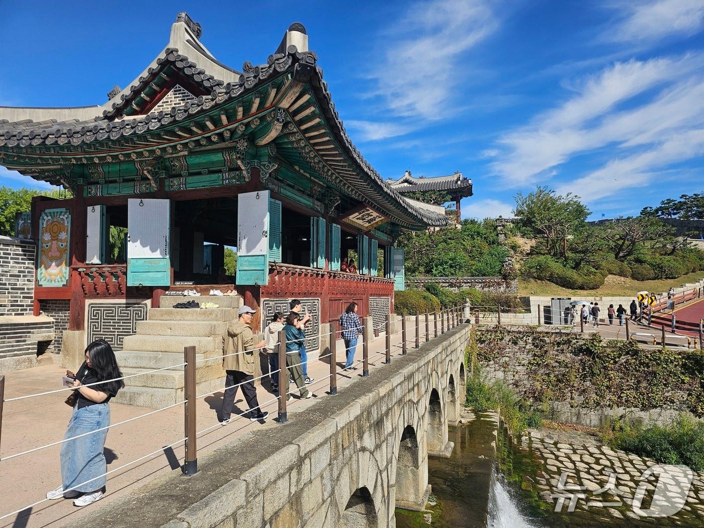 본문 이미지 - 3일 경기 수원시 팔달구 화홍문 일대를 산책하는 시민들. 2026.10.3 ⓒ 뉴스1 유재규 기자