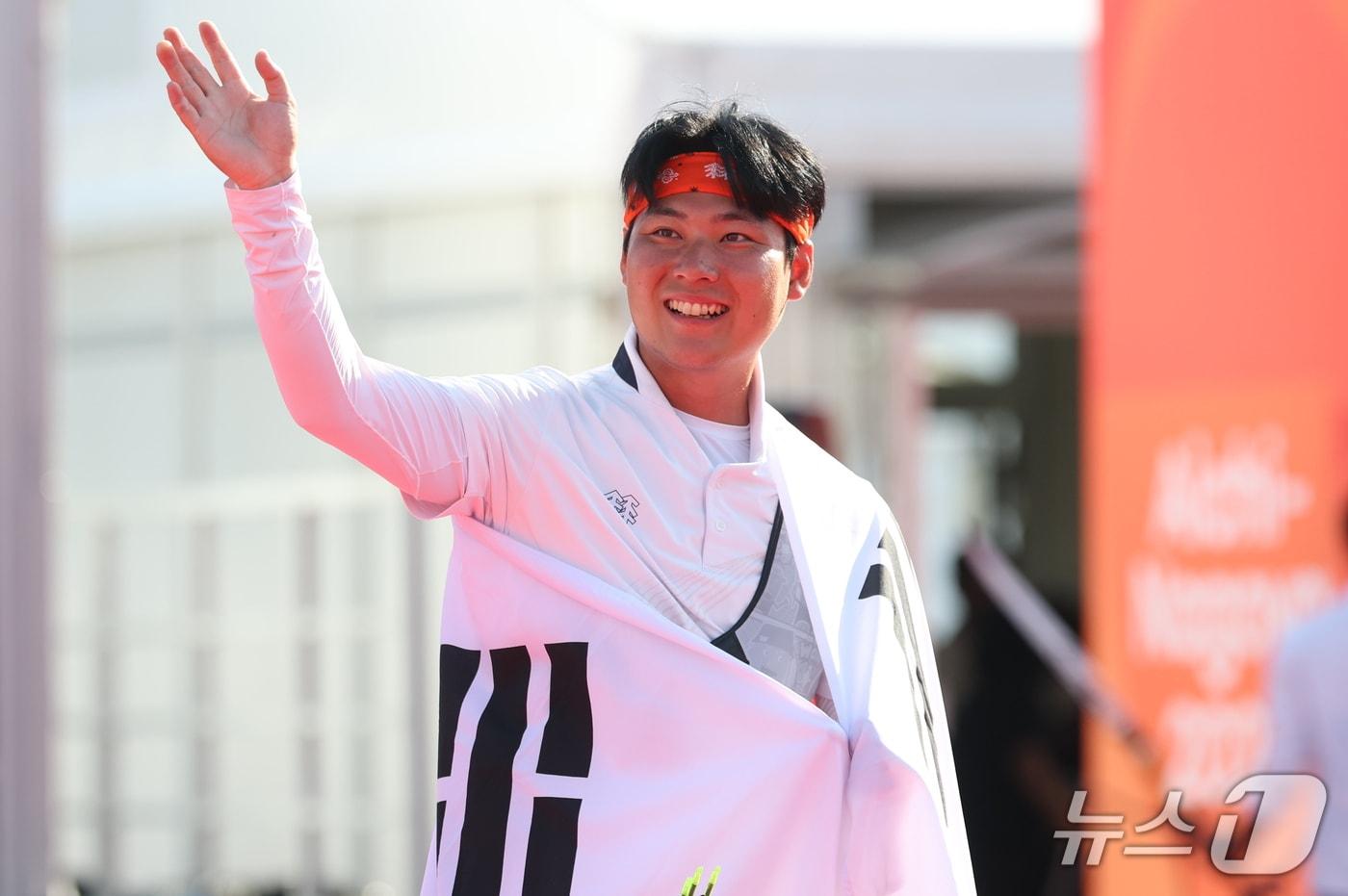 본문 이미지 - 대한민국 이우석이 3일 일본 오카자키 중앙종합공원 다목적광장에서 열린 2026 아이치·나고야 아시안게임 양궁 리커브 남자 개인전 결승에서 일본 나카니시 준야를 꺾고 금메달을 확정지은 후 관중을 향해 손인사를 하고 있다. 2026.10.3 ⓒ 뉴스1 김도우 기자