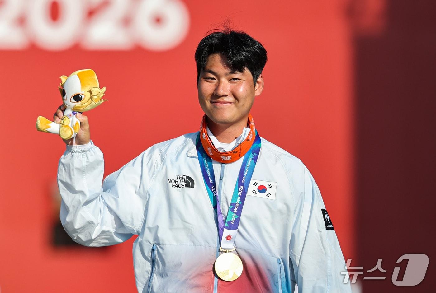 본문 이미지 - 대한민국 이우석이 3일 일본 오카자키 중앙종합공원 다목적광장에서 열린 2026 아이치·나고야 아시안게임 양궁 리커브 남자 개인전 시상식에서 금메달을 목에 걸고 기뻐하고 있다. 2026.10.3 ⓒ 뉴스1 김도우 기자