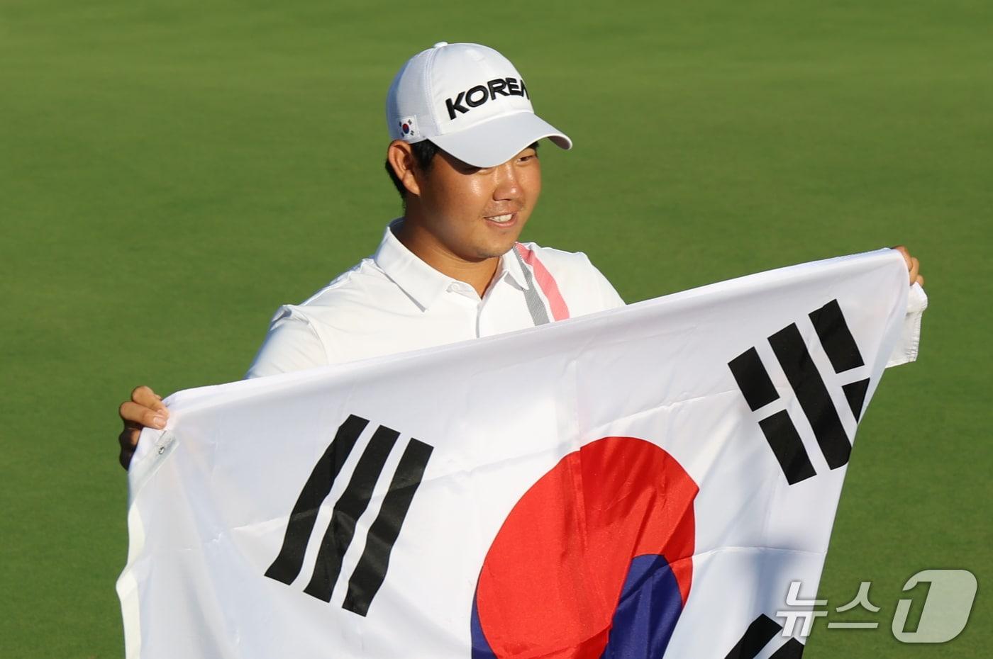 본문 이미지 - 대한민국 김주형이 3일 일본 아이치현 가스가이 컨트리클럽 동코스에서 열린 2026 아이치·나고야 아시안게임 골프 남자 개인 최종라운드에서 금메달을 확정지으며 태극기를 펼쳐들고 있다. 2026.10.3 ⓒ 뉴스1 김민지 기자