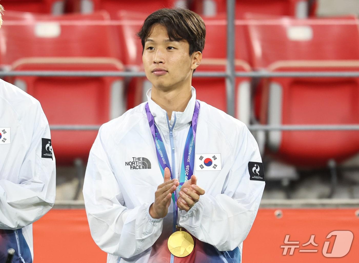 본문 이미지 - 대한민국 아시안게임 축구대표팀 엄지성이 3일 일본 아이치현 도요타 스타디움에서 열린 2026 아이치·나고야 아시안게임 축구 결승전 시상식에서 금메달을 목에 걸고 손뼉치고 있다. 2026.10.3 ⓒ 뉴스1 김도우 기자