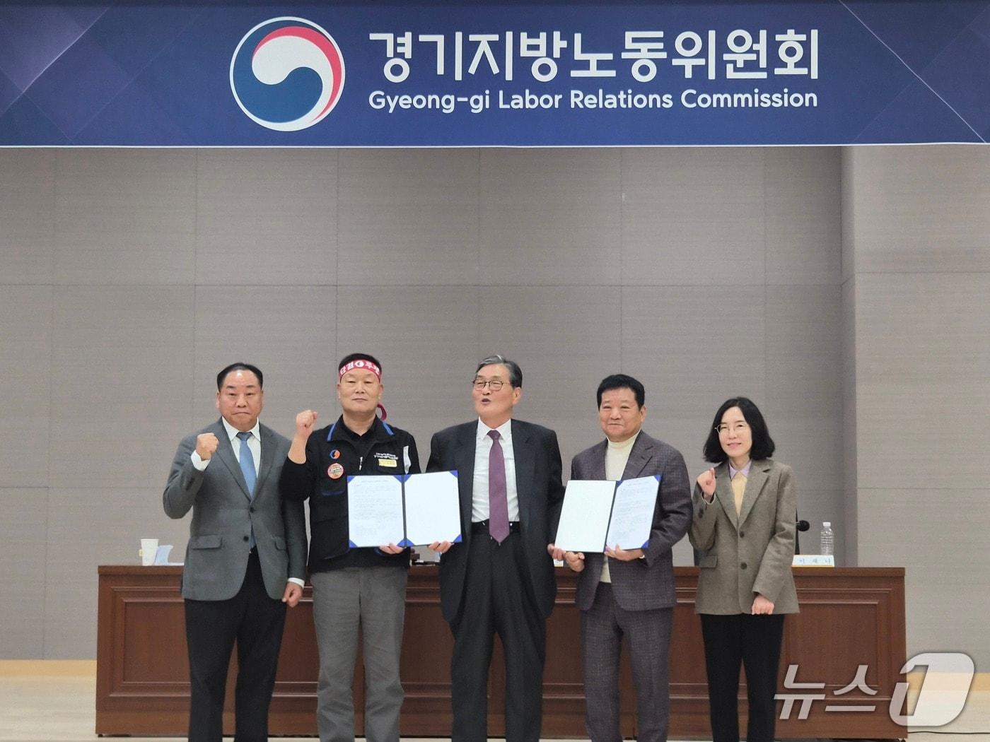 본문 이미지 - 우종현 경기지방노동위원회 공익위원(가운데)과 이기천 한국노총 전국자동차노동조합연맹 경기지역자동차노동조합 위원장(왼쪽 두 번째), 김기성 경기도버스운송사업조합 이사장(오른쪽 두 번째) 등이 30일 수원시 영통구 경기지노위에서 열린 최종 조정회의에서 합의한 후 기념촬영을 하고 있다. 2026.10.30/뉴스1 ⓒ 뉴스1 김기현 기자