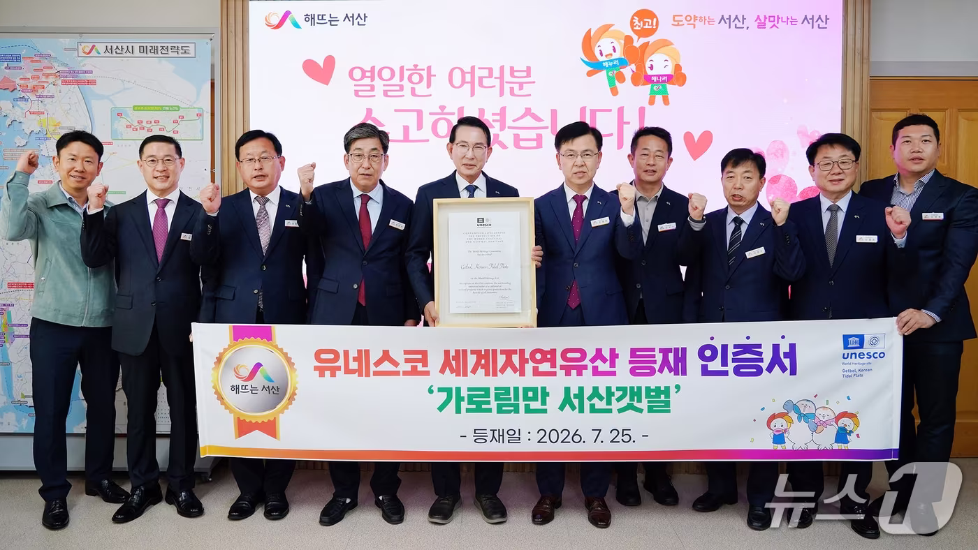 본문 이미지 - 이완섭 서산시장(왼쪽 다섯 번째))과 관계 공무원들이 가로림만 서산갯벌의 유네스코 세계자연유산 등재 인증서를 들고 기념촬영을 하고 있다.(서산시 제공. 재판매 및 DB 금지)