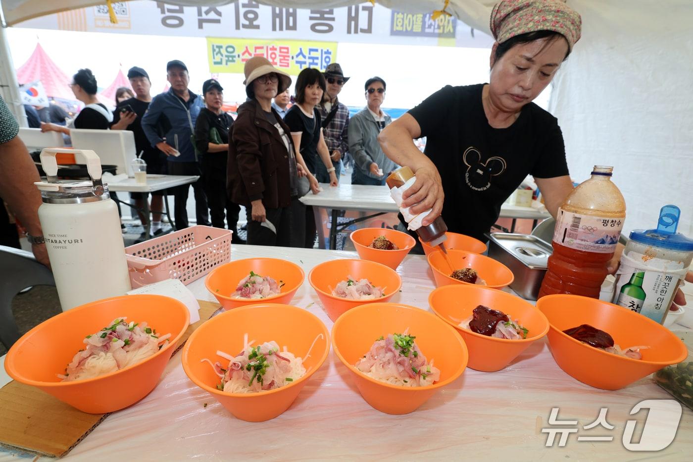 본문 이미지 - 4일 오후 경북 포항시 남구 구룡포 아라광장 일원에서 열린 '포항 해뜨면 국수축제'를 찾은 관광객들이 국수를 먹기 위해 줄을 서서 기다리고 있다. 이번 축제에는 관내 국수 맛집 24곳과 일본·중국 현지 셰프들이 사누키우동, 양저우 양춘면 시식 코너를 마련해 매일 오후 5시부터 선착순 100명씩에게 무료로 나눠준다. 2026.10.4 ⓒ 뉴스1 최창호 기자