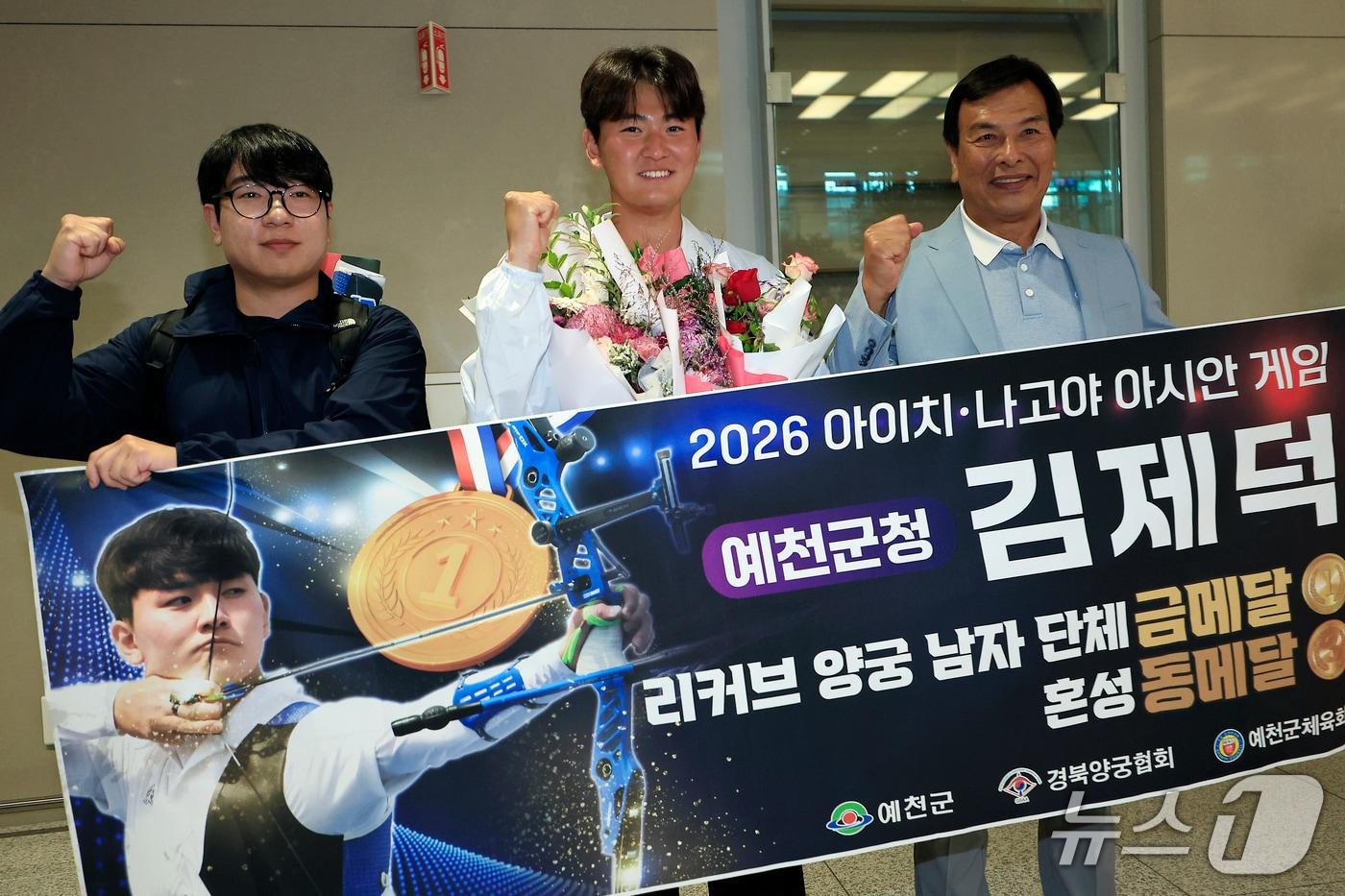본문 이미지 - 2026 아이치-나고야 아시안게임 양궁 리커브 남자 단체 금메달과 혼성 동메달을 차지한 김제덕이 4일 오후 인천국제공항을 통해 귀국해, 관계자들과 기념 촬영을 하고 있다. 2026.10.4 ⓒ 뉴스1 박정호 기자